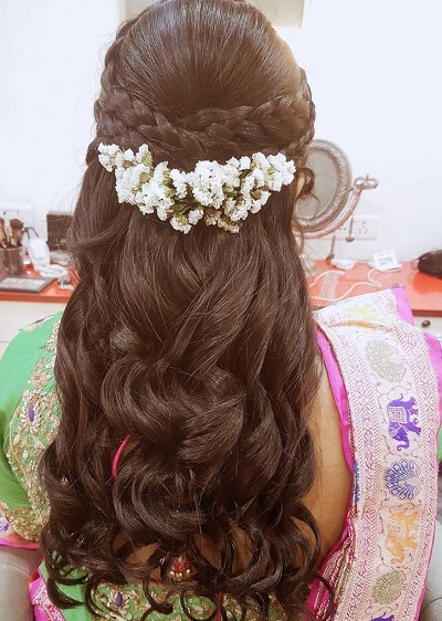 Half updo braided hairstyle with flower clip