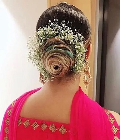 Intricate low juda hairstyle with floral detailing