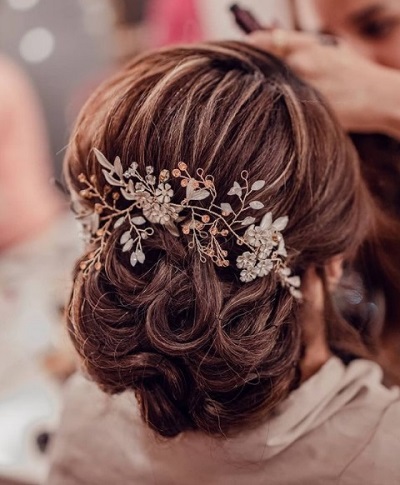 Low bun with rolled out roses hairstyle For reception