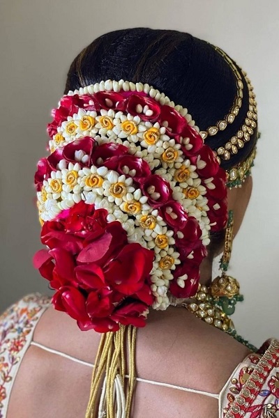Red and white floral covering the bun hairstyle for brides