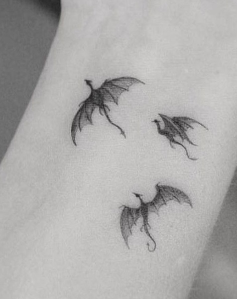 Multiple Flocking Dragon Wrist Tattoo